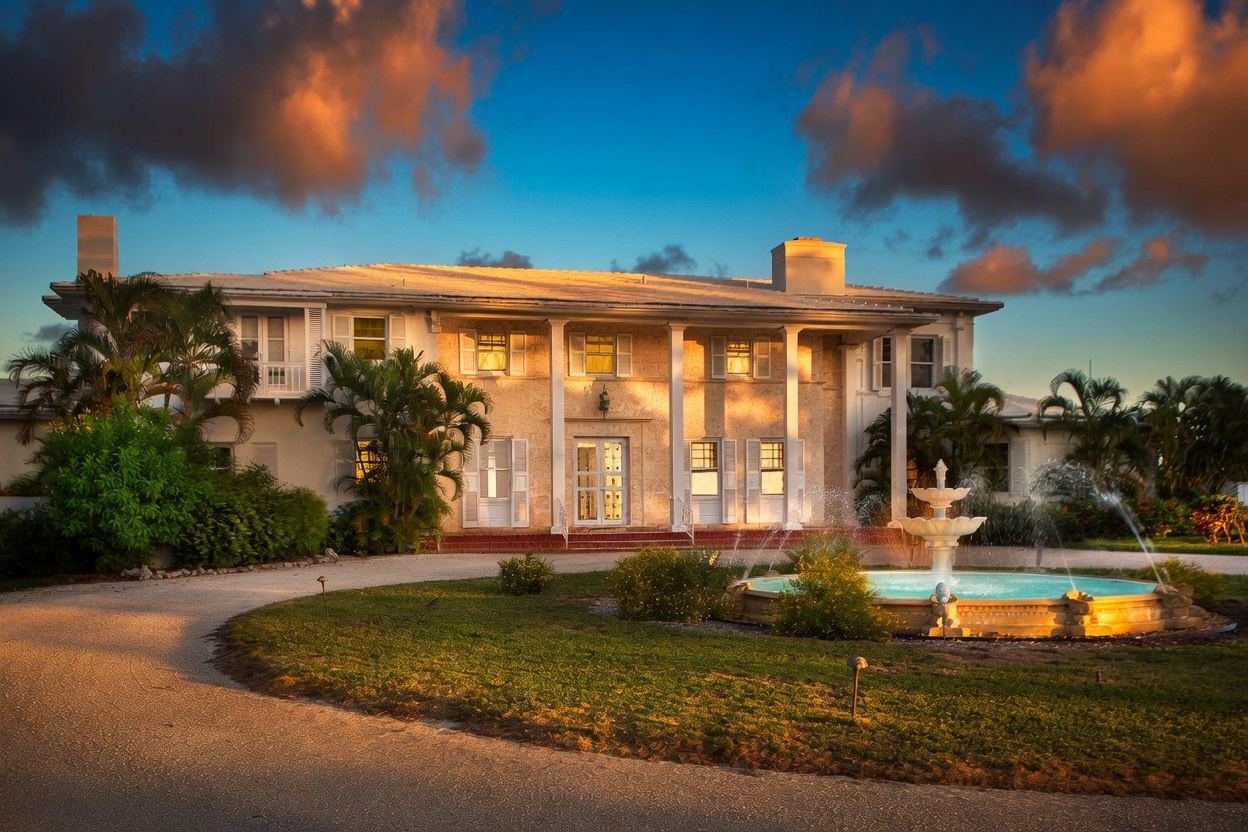 Thompson Island main house at sunset with lit fountain and columned facade
