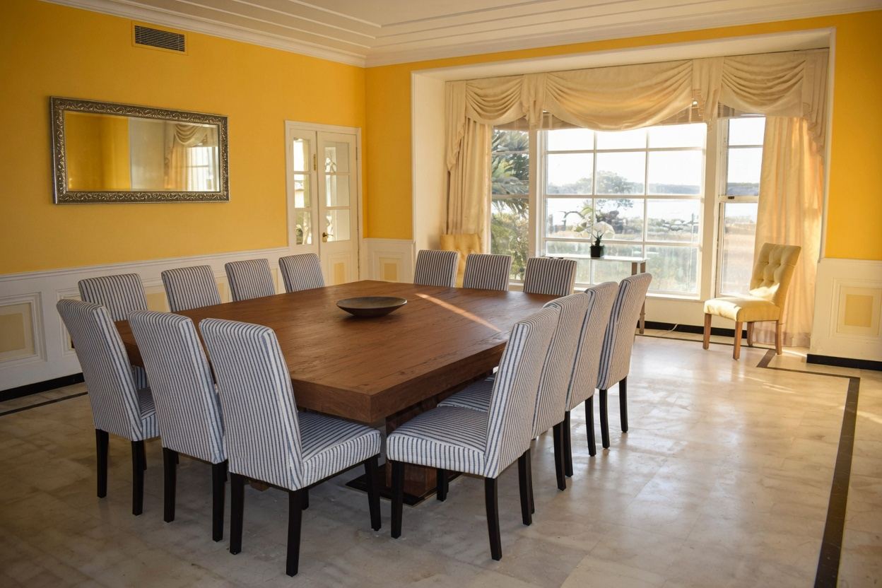 Grand yellow dining room with seating for 16 and waterfront views at Thompson Island